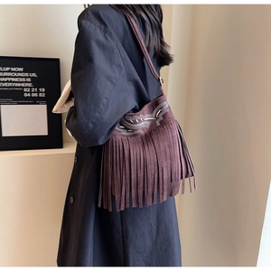 Détail du sac seau bohème en daim marron foncé avec broderie ethnique et longues franges