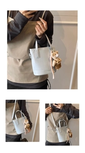 Light blue bucket bag featuring a cute teddy bear charm and silver logo details