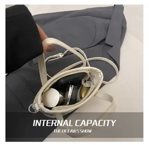 Internal capacity of the white leather bucket bag showing phone and cosmetics inside