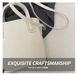 Detail shot of the fine stitching and matte white leather texture of the bucket bag