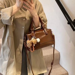 Retro deep brown Boston bag with oil-wax texture and cute bear charm shown on a model