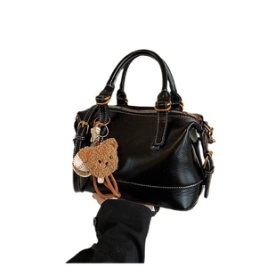 Vintage black Boston handbag with leather texture, adjustable strap and cute bear charm