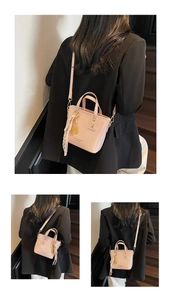 Detail of pink PU leather bucket bag with gold tennis racket charm and tassel ornament