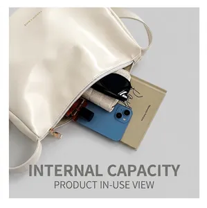 Vista dettagliata della capacità interna della borsa tote crema con oggetti quotidiani