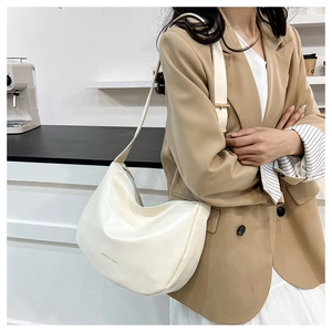 Dettaglio della borsa a mezzaluna bianco crema con logo FASHION & BAGS e pelle PU lucida