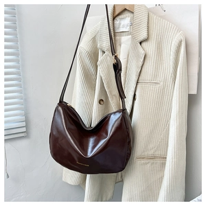 Dettaglio borsa hobo in pelle marrone scuro con scritta dorata e tracolla regolabile