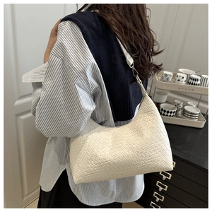Detail showing white woven texture and silver buckle on an elegant hobo shoulder bag