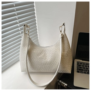 Detail of white woven leather texture on a crescent shoulder bag with gold metal buckle