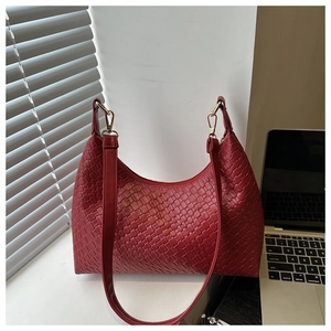 Close-up of red woven PU leather tote with elegant gold metal hardware and straps