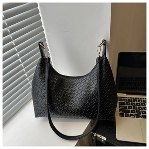 Detailed close-up of the black woven texture and gold hardware on a hobo bag