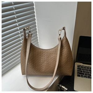 Macro detail of tan woven checkerboard texture and golden metal zipper on hobo bag