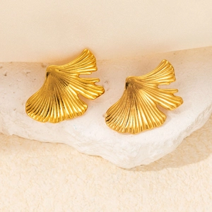 Detailed close-up of golden ginkgo leaf earrings with intricate vein textures on stone