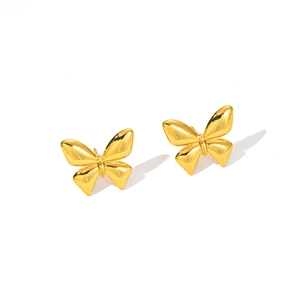 Macro detail of polished gold butterfly stud earrings with high-shine metallic finish