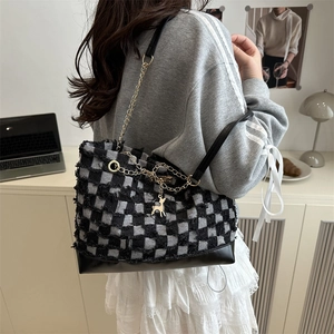 Chic black and white checkerboard tote bag with gold chain strap and leather bottom