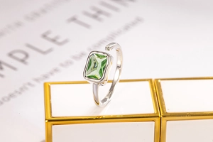 Macro shot of S925 silver ring featuring an emerald-cut green zircon on a white pedestal