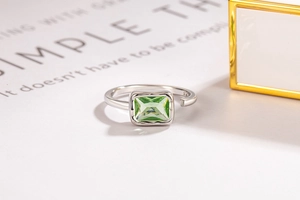 Macro shot of silver adjustable ring featuring a rectangular emerald green zircon stone