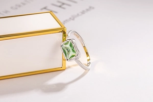 Macro detail of 925 sterling silver stamp and emerald-cut green zircon on the ring