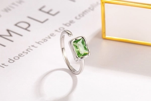 Detail of adjustable S925 silver ring featuring emerald cut green zircon on magazine