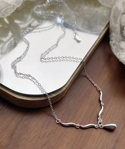 Macro shot of S925 sterling silver stamp on water drop pendant necklace with wavy links