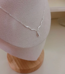 Detail of S925 sterling silver necklace with curved bar and water drop pendant