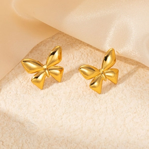 Elegant gold butterfly stud earrings in polished stainless steel on a silk background