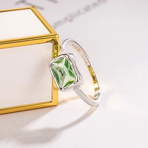Minimalist S925 silver adjustable ring with emerald-cut green zircon on white pedestal