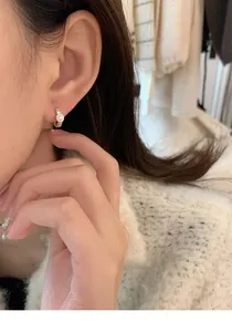 Close-up of elegant S925 sterling silver hoop earrings with small white pearl on model