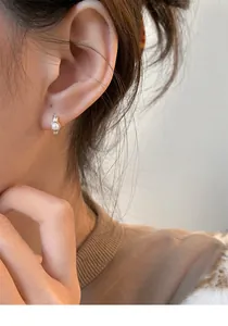 Close-up of a S925 silver pearl hoop earring worn gracefully on a female ear model