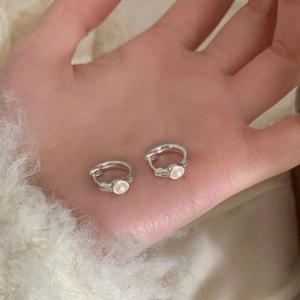 Elegant S925 sterling silver hoop earrings with small white pearls held by hand