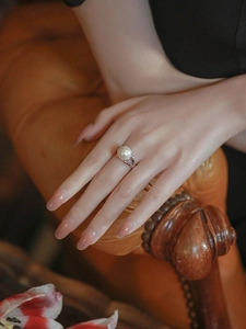 Detailed view of an elegant large white pearl ring on a silver split-shank band