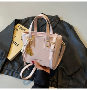 Pink patent leather bucket bag with gold hardware and stylish brand logo detail