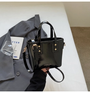 Glossy black patent leather mini tote bag with silver hardware and adjustable strap