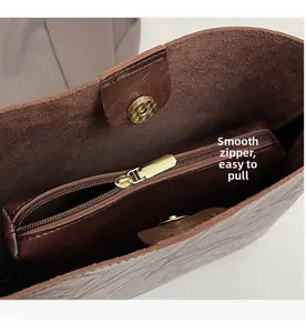 Detail of the brown leather tote bag interior showing smooth metal zipper and magnetic buckle