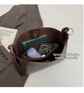 Interior view of large brown vintage bucket bag showing spacious storage and golden clasp