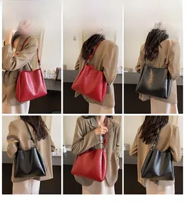 Detail view of large PU leather tote bags in red and black with knotted shoulder straps