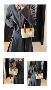 Detail of embossed tote bag with cartoon patterns, brown handles and white plush charm