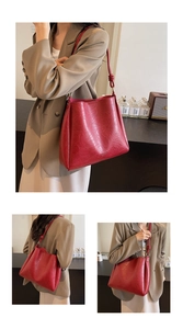 Detail view of red retro tote bag with textured leather and minimalist knot strap design