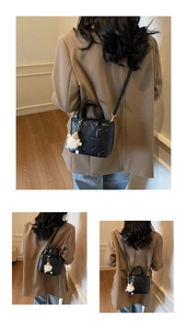 Detail of black embossed mini bucket bag featuring cute patterns and a plush charm