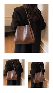 Detailed view of the dark brown retro leather texture and knot detail on the bucket bag