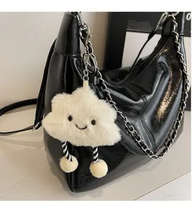 Plush cloud charm with smiling face and striped legs on black leather tote bag