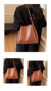 Detail of caramel brown bucket bag with decorative knotted shoulder strap detail