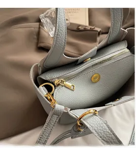 Detail view of leather bucket bag interior with zipper compartment and gold hardware