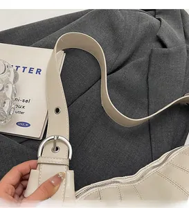 Close-up of beige leather bag detail with silver zipper and refined stitching