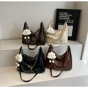 Detail of four faux leather hobo bags with silver chains and fluffy cloud charms