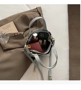 Spacious interior of blue leather bucket bag showing storage for phone and wallet