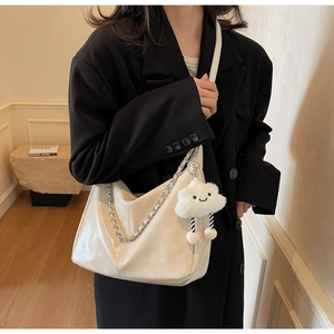 Detail of off-white patent leather hobo bag with silver chain and cute cloud charm