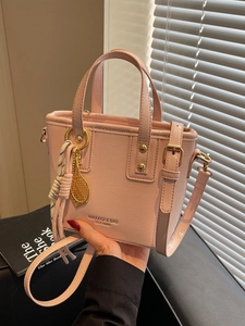 Pink faux leather bucket bag with tennis charm and crossbody strap for women