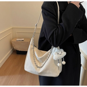 Detail view of white soft PU tote bag with chunky silver chain and plush cloud charm