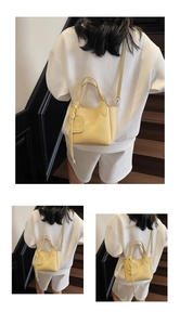 Three-way view of pale yellow pebble leather bucket bag with cute bear charm and strap