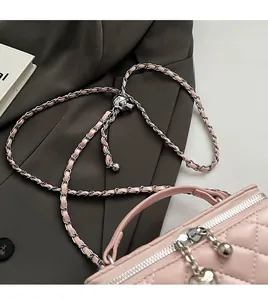 Detailed shot of pink quilted bag with silver chain strap and heart zipper charm